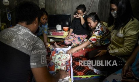 Evan Zendarto (kiri) dan Lasmayani (kedua kanan) menangis saat melihat anak pertamanya yang meninggal di Jalan Lintas Timur, Kulim, Pekanbaru, Riau, Kamis (19/9).