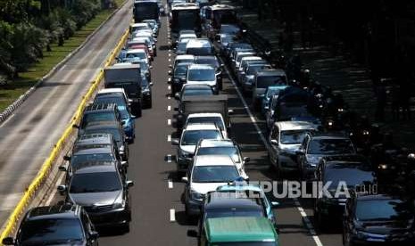 Antrean kendaraan yang melintas saat penerapan sistem ganjil genap di Jalan Medan Merdeka Barat, Jakarta, Senin (3/9).