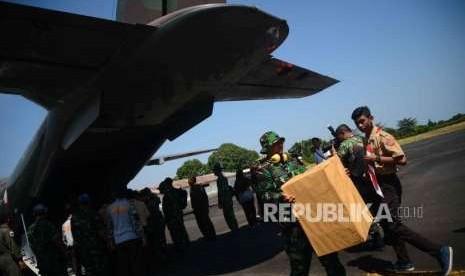 Anggota TNI  memindahkan   bantuan dan logistik  menuju mobil  saat tiba di lanud zam, Mataram,  Lombok, Nusa Tenggara Barat, Kamis (8/9).