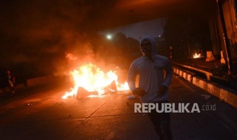 Massa Aksi Mahasiswa Indonesia berlari menghindari gas air mata saat aksi di depan kawasan Jalan Tol Dalam Kota Gatoto Soebroto, Jakarta, Selasa (24/9/2019).