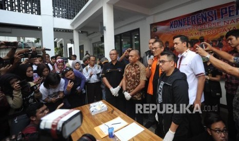 Tersangka kasus narkoba yang juga aktor senior Tio Pakusadewo (tengah) dihadirkan saat rilis kasus narkoba, di Polda Metro Jaya, Jakarta, Jumat (22/12).