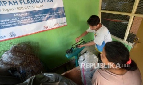 Umar petugas bank sampah menimbang sampah di bank Sampah Flamboyan, Jakarta, Senin (15/10).