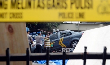 Sejumlah petugas kepolisian mengevakuasi mobil yang hancur pasca peristiwa perusakan dan pembakaran di gedung Polsek Ciracas, Jakarta, Rabu (12/12).