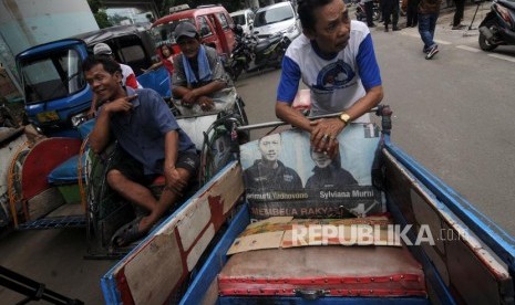 Tukang becak saat menunggu untuk didata oleh petugas di kolong flyover Bandengan Utara, Pekojan, Tambora, Jakarta Barat, Jumat (26/1).