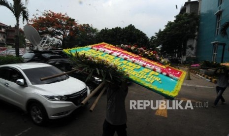 Pekerja memindahkan karangan bunga untuk Ketua DPR RI Setya Novanto yang sedang dirawat di RSCM Kencana, Jakarta, Sabtu (18/11).