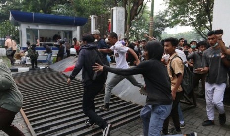 Massa merobohkan pagar gedung DPRD Kota Medan saat unjuk rasa menolak UU KPK hasil revisi dan RUU KUHP, di Medan, Sumatera Utara, Jumat (27/9/2019).