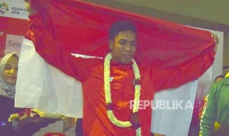 Atlet Athletik Indonesia  Lalu Muhammad Zohri  memegang bendera merah putih saat tiba  di Indonesia dari Finlandia di Bandara Internasional Soekarno Hatta, Tangerang,Banteng,Selasa (17/7).