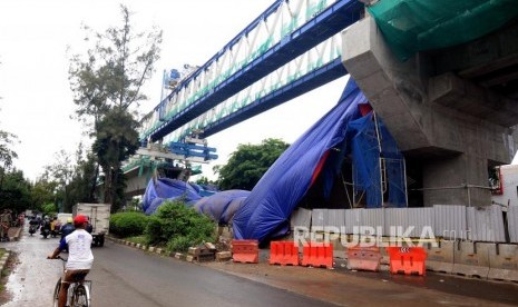 Kendaraan melintas di samping konstruksi proyek Light Rapid Transit (LRT) yang roboh di kawasan Jalan Raya Kayu Putih, Pulogadung, Jakarta Timur, Senin (22/1).