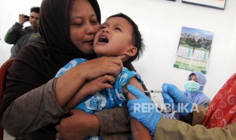 Imunisasi Massal Difteri. Seorang balita saat disuntik imunisasi Difteri di Posyandu Mawar, Pancoran Mas, Kota Depok, Jawa Barat, Senin (11/12).