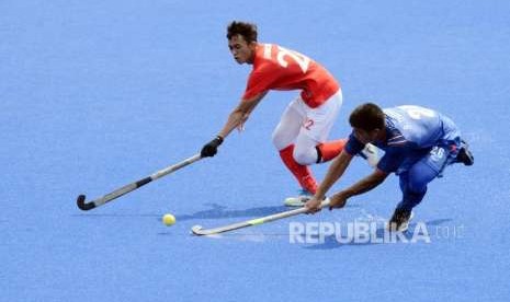 Atlet Hoki Indonesia Astri Rahmad (kiri) berebut bola dengan Atlet Hoki Thailand Thanakrit Boon Art pada pertandingan cabang olahraga Hoki Asian Games 2018 di Lapangan Hoki Komplek Gelora Bung Karno, Kamis (30/8).