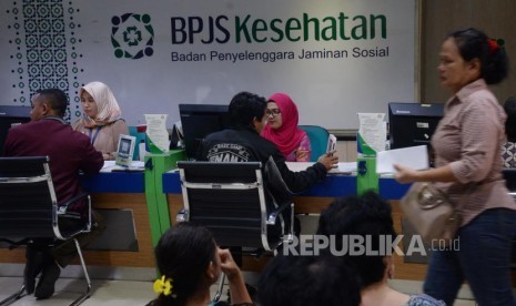 Petugas melayani warga di kantor Badan Penyelanggara Jaminan Sosial (BPJS) Kesehatan KCU Jakarta Pusat, Rabu (1/11).