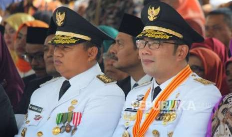 Gubernur Jawa Barat yang baru, Ridwan Kamil (Emil) dan Uu Ruzhanul Ulum duduk berdampingan pada acara Serah Terima Jabatan Gubernur Jawa Barat, di Halaman Gedung Sate, Kota Bandung, Kamis (6/9).