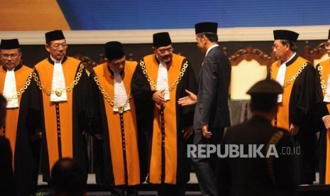 Presiden Republik Indonesia Joko Widodo bersalaman bersama Ketua Mahkamah Agung (MA) Hatta Ali usai berfoto bersama dalam acara laporan tahunan Mahkamah Agung (MA) di JCC, Jakarta, Kamis (1/3).