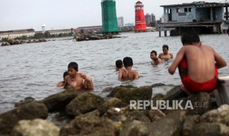 Anak-anak bermain di pesisir laut di Kawasan Muara Baru, Jakarta, Kamis (28/12).