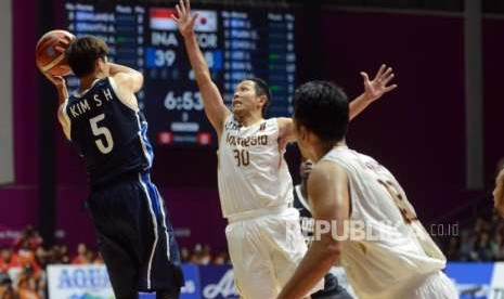 Pemain basket Indonesia Prawiro Xaverius menghalau lemparan bola pemain basket Korea Kim Sunhyung pada babak penyisihan Grup A Asian Games 2018 di Hall Basket Senayan, Jakarta, Selasa (14/8).