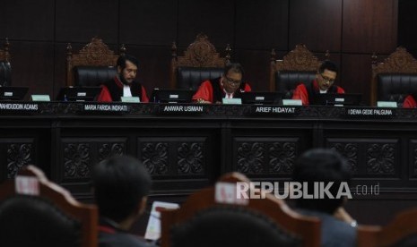 Ketua Majelis Hakim Mahkamah Konstitusi (MK) Arief Hidayat (tengah) bersama Hakim MK Anwar Usman (kiri) dan I Dewa Gede Palguna (kanan) membacakan putusan sepuluh perkara PUU, di ruang sidang gedung MK, Jakarta, Selasa (12/12).