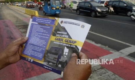 Petugas Dinas Perhubungan DKI Jakarta menunjukan brosur uji coba perluasan sistem ganjil genap kepada pengendara di kawasan Pramuka, Jakarta, Senin (12/8).