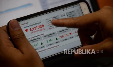 Seorang karyawan mengamati pergerakan Indeks Harga Saham Gabungan (IHSG) melalui gadget.  Ilustrasi