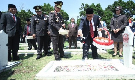 Gubernur Jawa Barat Ahmad Heryawan menaburkan bunga usaia upacara peringatan Hari pahlawan di Taman makam Pahlawan Cikutra, Kota Bandung, Kamis (10/11).