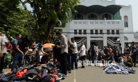 Sejumlah pedagang menggelar barang daganganya usai Shalat Jumat di halaman Masjid Cut Meutia, Jakarta, Jumat (26/7).