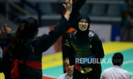 Pesilat Indonesia Pipiet Kamelia (pita biru) bertanding melawan Pesilat Singapura Nurul Suhaila Mohd Saiful pada babak perempat final cabang pencak silat putra kelas D 60-65 kg Asian Games 2018 di Padepokan Pencak Silat TMII, Jakarta, Jumat (24/8).