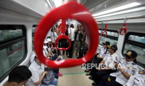 Para petugas menaiki kereta light rail transit (LRT) saat uji coba di Stasiun LRT Velodrome, Jakarta, Rabu (15/8).