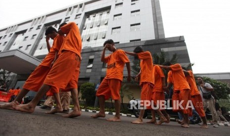 Petugas membawa tersangka seusai rilis operasi Premanisme di Polda Metro Jaya, Jakarta, Kamis (14/12).