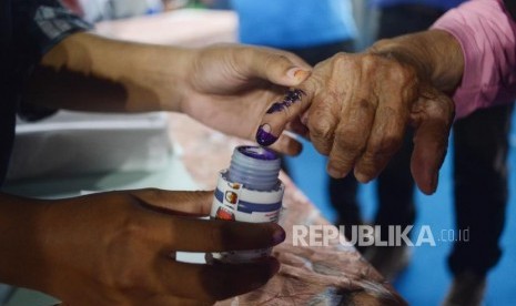 Petugas mencelupkan tinta kepada warga saat melakukan simulasi pencoblosan pemilu  (ilustrasi)