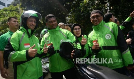 Founder dan CEO Gojek Grup Nadiem Makarim berfoto dengan mintra Gojek sebelum mengikuti konvoi saat peresmian logo baru Gojek di Jakarta, Senin (22/7).