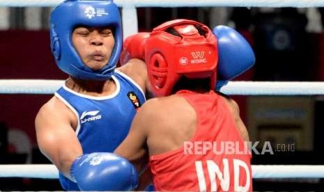 Petinju Indonesia Huswatun Hasanah (biru) saat berlaga dengan petinju petinju India Pavita dalam pertandingan perempat final cabang Tinju Kelas ringan putri 57-60 Kg Asian Games 2018 di Hall Jakarta International Expo, Kemayoran, Jakarta, Selasa (28/8).