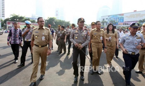 Gubernur DKI Jakarta Anies Baswedan (kiri) bersama Wakil Gubernur DKI Jakarta Sandiaga Salahudin Uno (kanan) dan Kapolda Metro Jaya Inspektur Jenderal Polisi Idham Azis (tengah) berjalan seusai apel Mantap Praja Jaya 2017 di Polda Metro Jaya, Jakarta, Selasa (31/10).