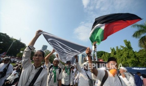 masa  reuni aksi 212 membawa spanduk tauhid dan bendera palestina saat  reuni aksi 212  di Lapangan Monumen Nasional, Jakarta, Ahad, (2/12).