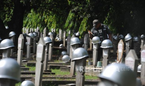 Mengecat. Petugas TMP Kalibata mengecat helm di TMP Kalibata, Jakarta, Rabu (8/11). Menjelang peringatan hari pahlawan TMP Kalibata melakukan persiapan seperti mengecat dan menambah bunga di setiap makam yang berada di TMP Kalibata.