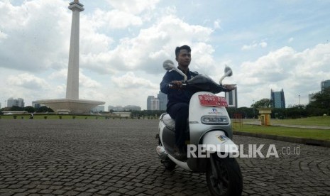 Petugas mengendarai motor listrik di Monumen Nasional, Jakarta, Jumat (14/12).