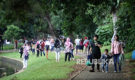 Warga berwisata ke Kebun Raya Bogor, Jawa Barat, Sabtu (23/12).