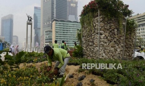 Petugas menyusun tanaman di dekat instalasi batu gabion di Bundaran HI, Jakarta, Jumat (23/8).