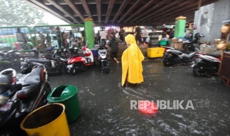 Warga melintasi genangan air di Pasar Blok G Tanah Abang