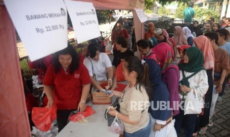 Sejumlah warga mengantri untuk membeli bawang putih dan bawang merah ketika gelar pangan murah berkualitas di Toko Tani Indonesia Center, Jakarta, Ahad (5/5).