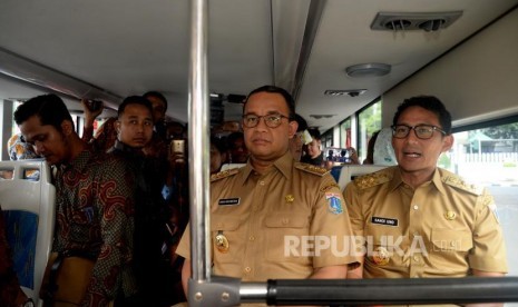 Gubernur DKI Jakarta Anies Baswedan dan Wakil Gubernur Sandiaga Uno menaiki bus City Tour di Halte Dukuh Atas, Jakarta, Selasa (17/10).