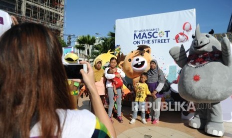 Warga berfoto bersama Ketiga Maskot Asian Games 2018  Bhin-Bhin, Atung, dan Kaka  dikawasan hari bebas berkendara / Car Free Day di Bundaran HI, Jakarta, Ahad. (1/4).