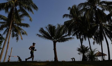 Peserta berlari ketika mengikuti Rhino Cross Triathlon 2018 di Kawasan KEK Tanjung Lesung, Pandeglang, Banten, Minggu (30/9).