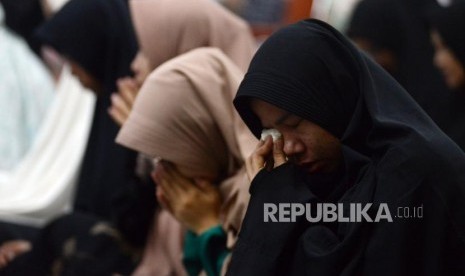 Sejumlah umat Islam menangis saat acara Dzikir Nasional di Masjid Agung At Tin, Jakarta, Senin (31/12).