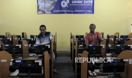 Staf guru mengecek komputer yang akan digunakan untuk Ujian Nasional Berbasis Komputer (UNBK) di SMA Negeri 40, Jakarta Utara, Jumat (6/4).