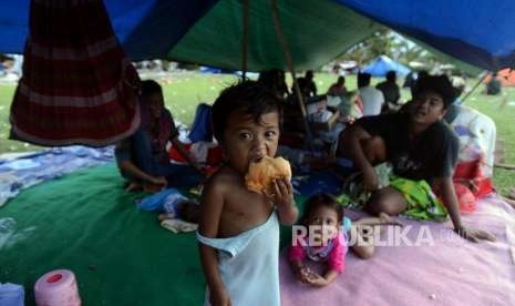 nak-anak memakan roti di tenda pengungsian di Lapangan Vatulemo, Palu, Sulawesi Tengah.