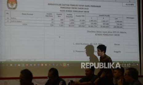 Peserta rapat pleno  melintasi paaparan  perbaikan Daftar Pemilih Tetap (DPT) di Kantor KPU, Jakarta, Minggu (16/9).