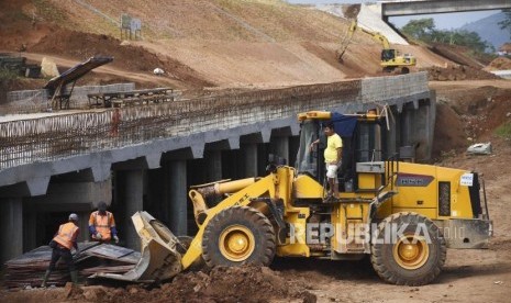 Pekerja menggunakan alat berat menyelesaikan pembangunan Jalan Tol Cileunyi-Sumedang-Dawuan (Cisumdawu) di Kabupaten Sumedang, Sabtu (1/6).