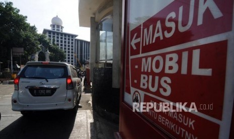 Pengendara mobil memasuki kawasan area parkir Masjid Istiqlal, Jakarta, Senin (25/12).