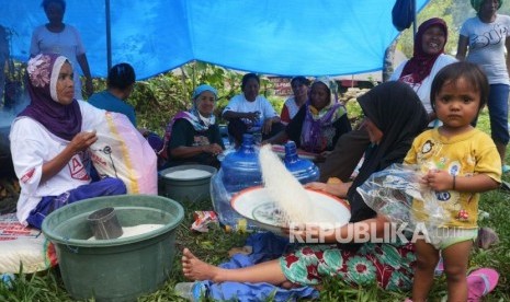 Ibu-ibu menampi beras yang akan di masak di dapur umum Posko Kemanusiaan ACT, di desa Lompio, Kabupaten Sirenja, Donggala Sulawesi Tengah, Ahad (14/10).