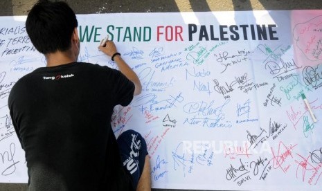 Aksi Bela Palestina. Warga melakukan tanda tangan pada aksi bela Palestina yang diusung oleh Masyarakat Relawan Indonesia (MRI) dan Aksi Cepat Tanggap (ACT) di Bundaran Hotel Indonesia (HI), Jakarta Pusat, Ahad (10/12).