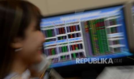 Seorang karyawan mengamati pergerakan Indeks Harga Saham Gabungan (IHSG) di Mandiri Sekuritas, Jakarta, Senin (3/9).